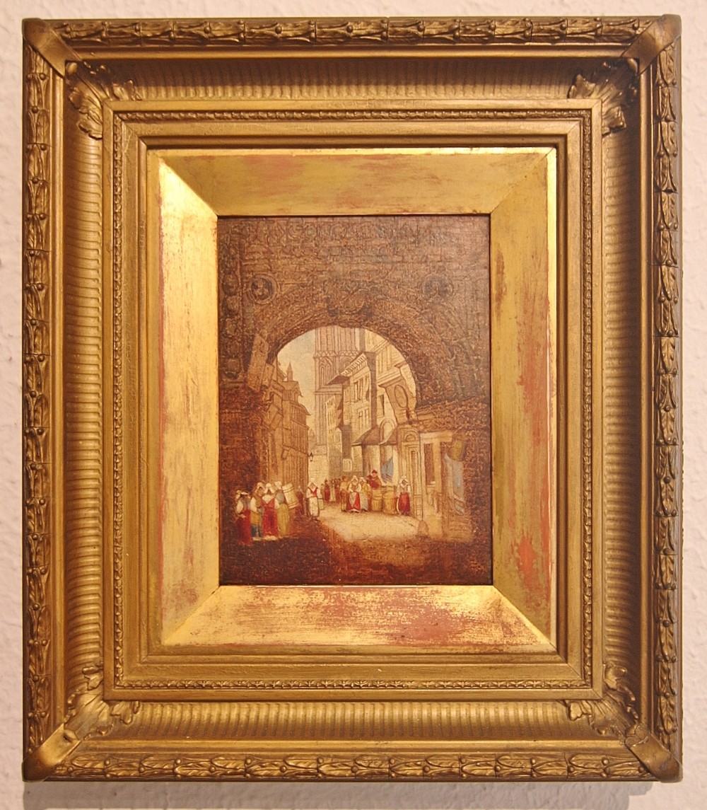 A late Georgian oil painting depicting figures walking through a arched European street scene, housed within a deep carved giltwood frame.