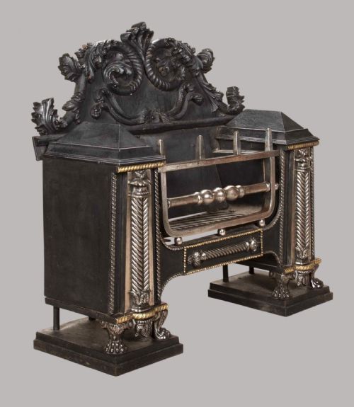 fig 1. A Georgian cast and wrought iron hob fire grate featuring fluted side panels, silver-toned highlights, polished steel bars, and an ornate acanthus cresting.