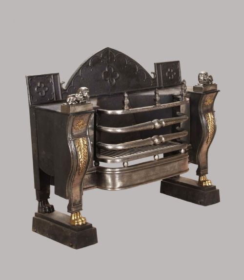 fig 1. A Regency cast iron hob fire grate featuring side plates with gilt leaf ornaments, lion figure mounts, lion paw feet, and an arched fireback.