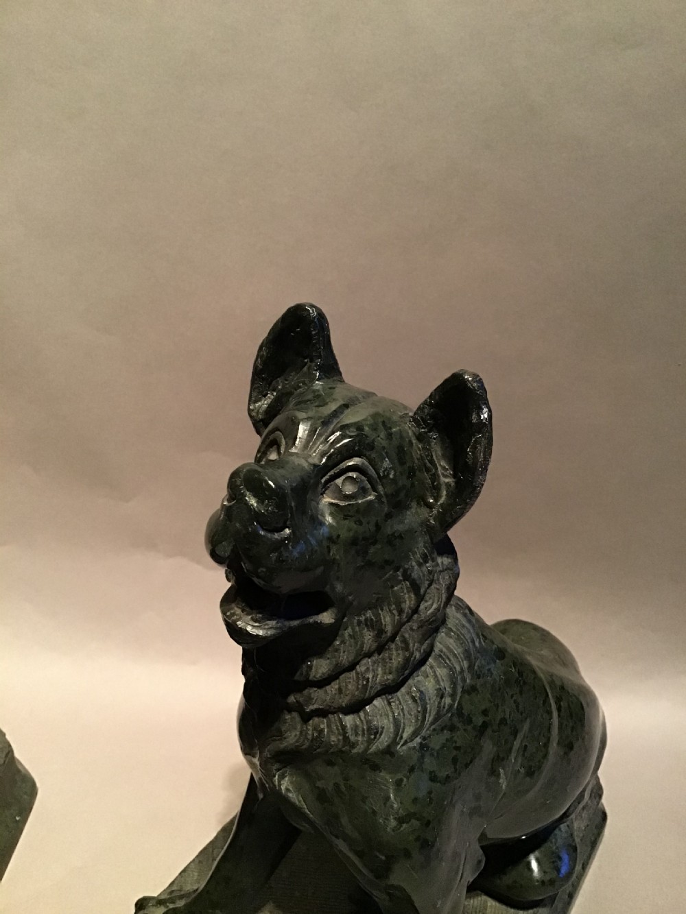 A pair of hand-carved dark green marble sculptures representing seated Alcibiades hounds on rectangular bases. View XI