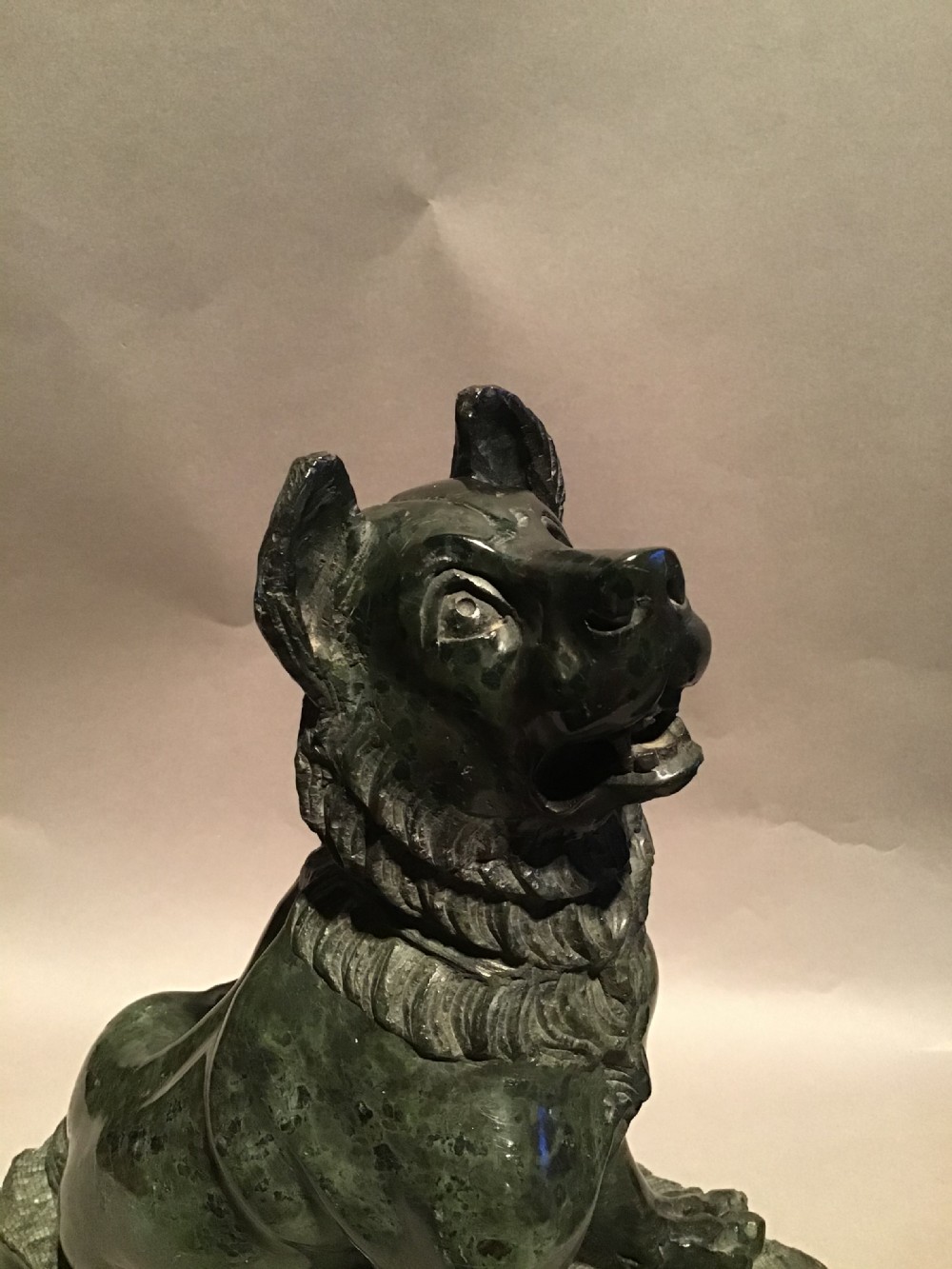 A pair of hand-carved dark green marble sculptures representing seated Alcibiades hounds on rectangular bases. View XII