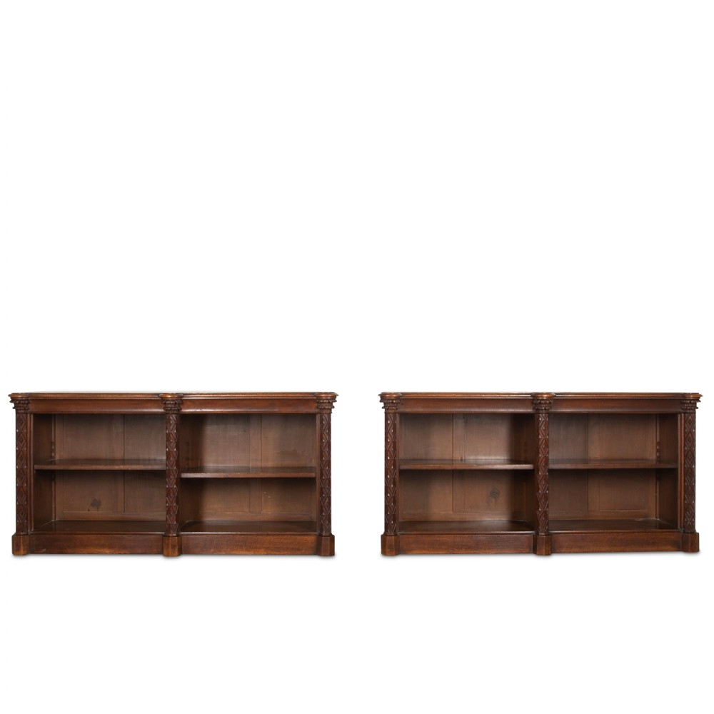 A pair of 19th-century dark wood low open bookcases featuring carved pilasters and open shelves.