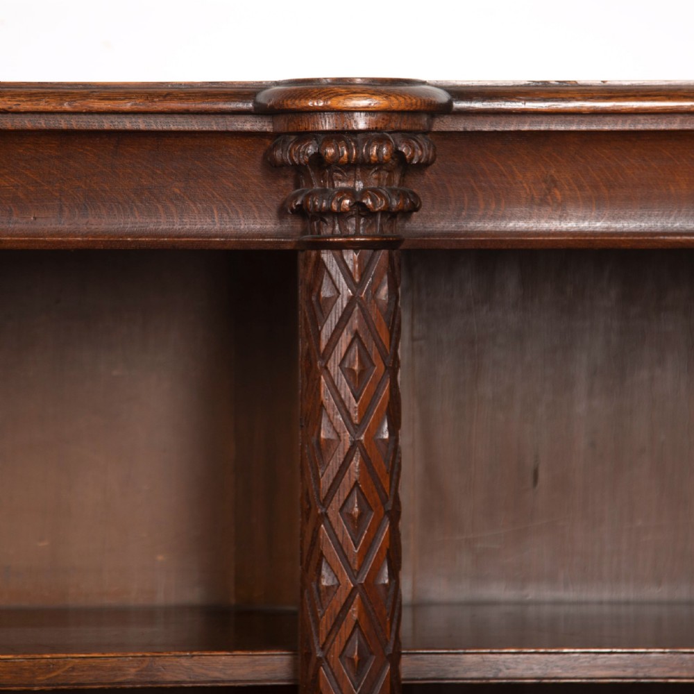 A pair of 19th-century dark wood low open bookcases featuring carved pilasters and open shelves. View VII