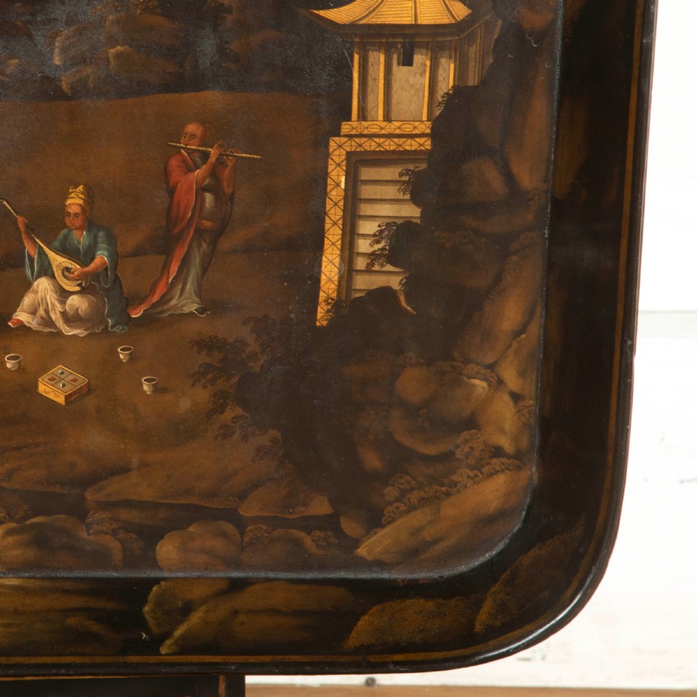 A Regency black lacquered and gilded papier-mache Chinoiserie tray featuring hand-painted pagodas and figures mounted on a dark wooden stand. View VI