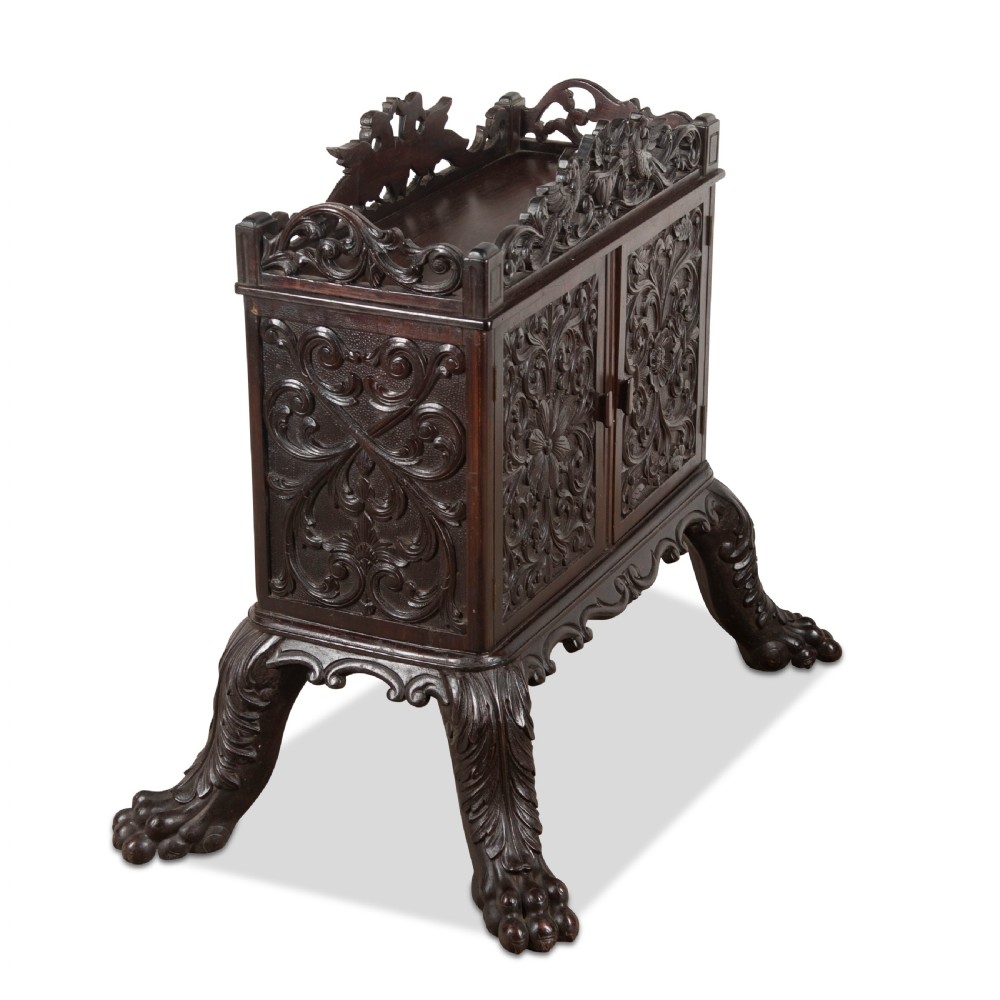 A small 19th-century dark hardwood Chinese cabinet featuring floral relief carving on double doors, an ornate carved cresting gallery, and heavy carved cabriole legs. View II