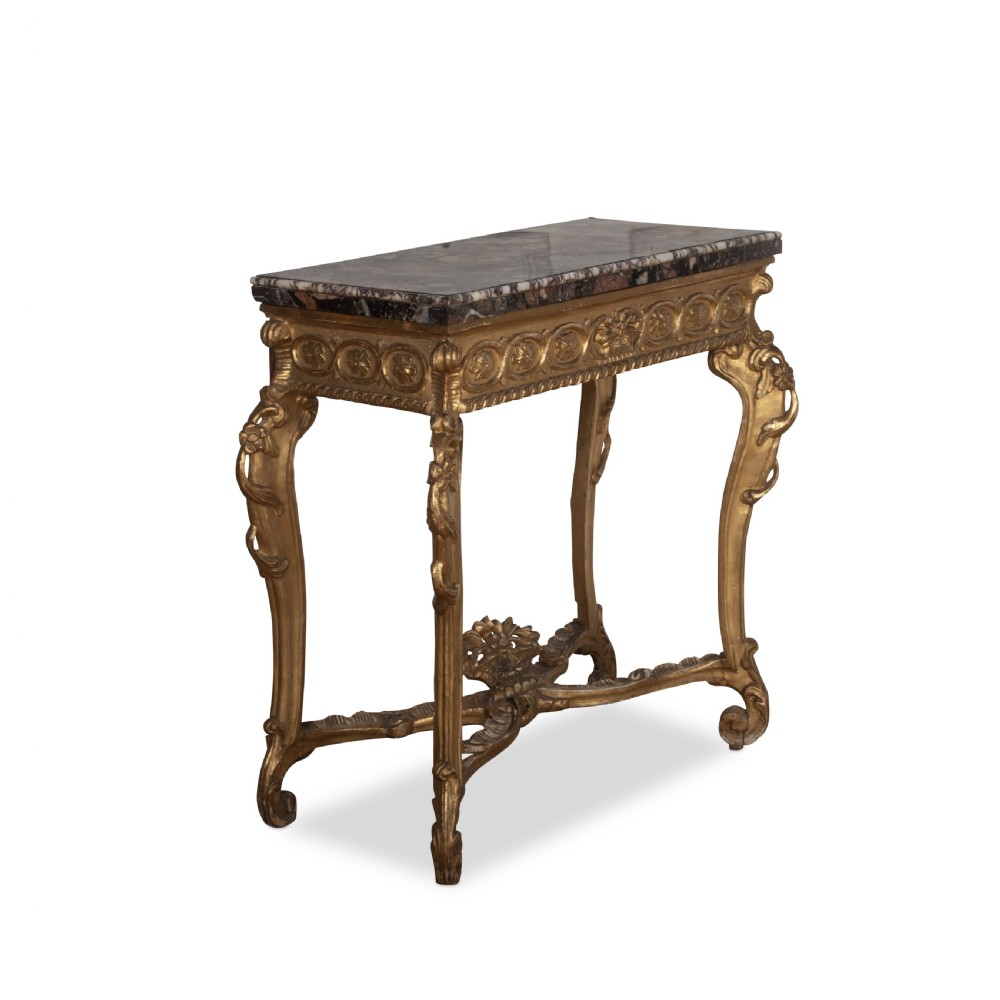 An 18th-century giltwood console table featuring a dark mottled marble top, carved apron with rosette motifs, and cabriole legs linked by an X-shaped stretcher. View III
