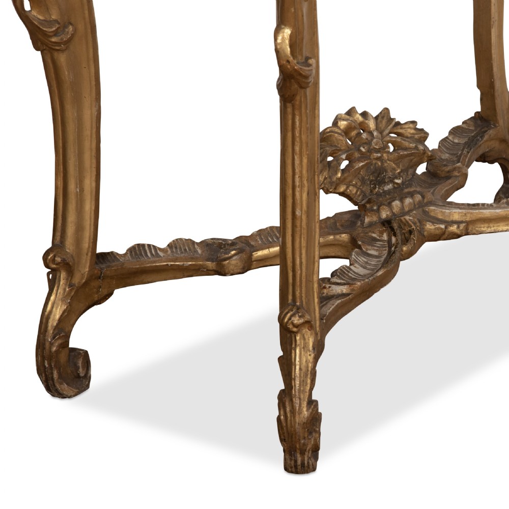An 18th-century giltwood console table featuring a dark mottled marble top, carved apron with rosette motifs, and cabriole legs linked by an X-shaped stretcher. View XII