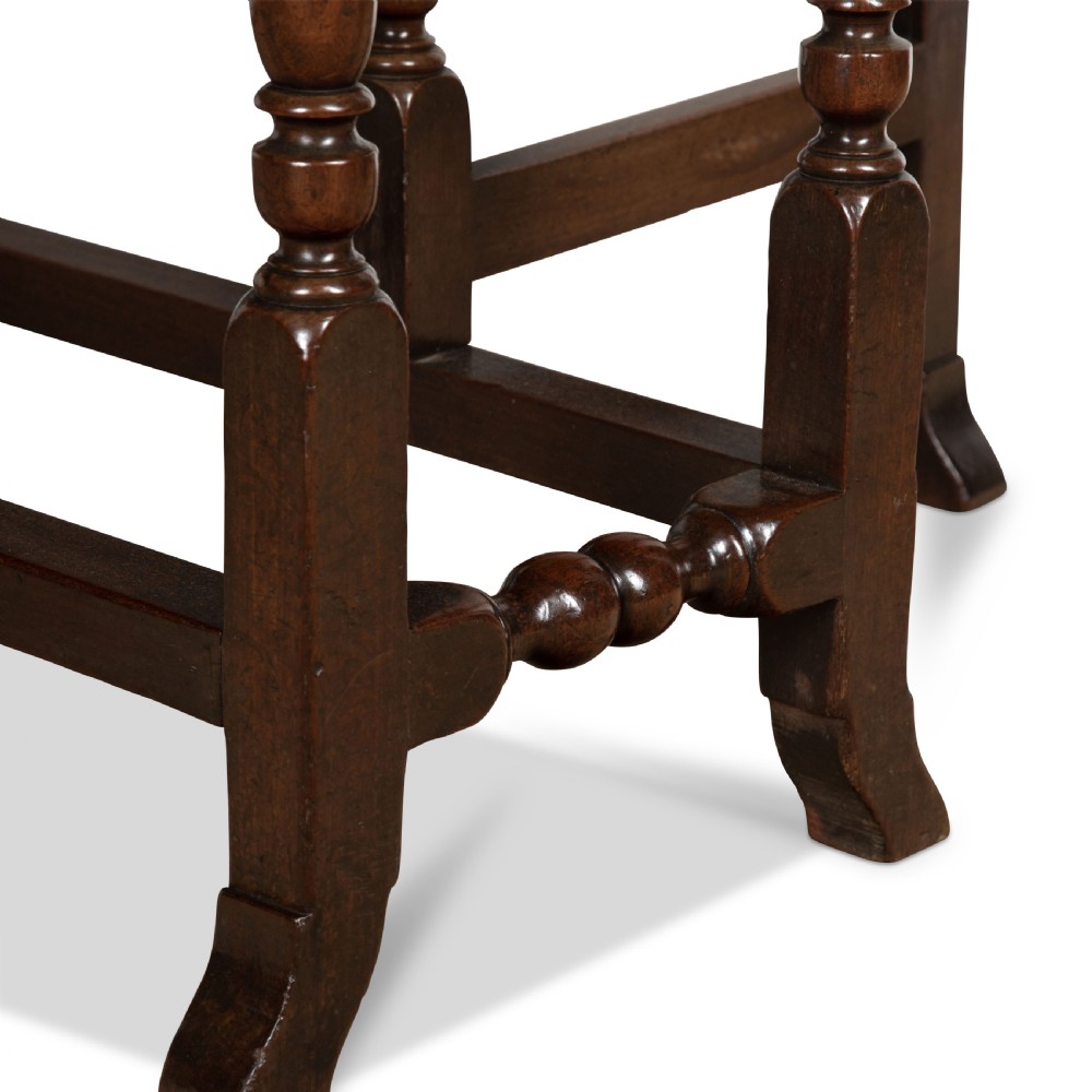 A dark brown Georgian walnut drop flap dining table featuring turned legs, bottom stretchers, an end drawer, and hinged oval leaves. View X