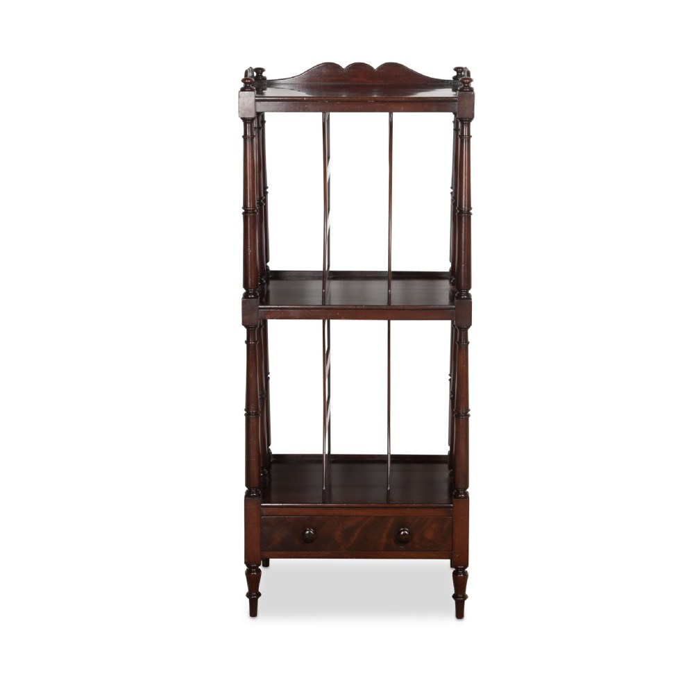 A tall dark mahogany etagere featuring three open shelves, vertical music dividers, turned spindle supports, a top gallery rail, and a single bottom drawer with turned wooden knobs.