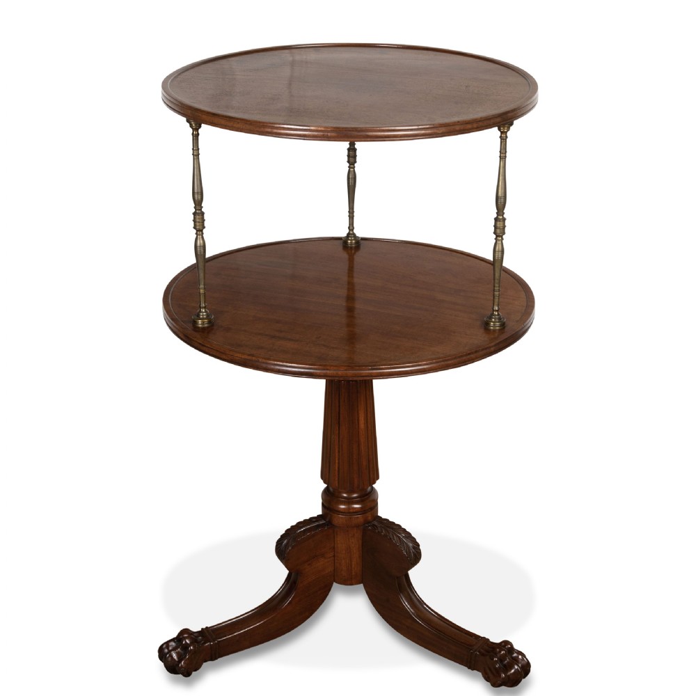 A two-tiered dark mahogany dumbwaiter featuring brass support columns, a fluted central pedestal, and a carved tripod base with paw feet.