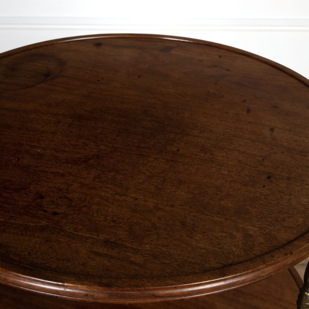 A two-tiered dark mahogany dumbwaiter featuring brass support columns, a fluted central pedestal, and a carved tripod base with paw feet. View III