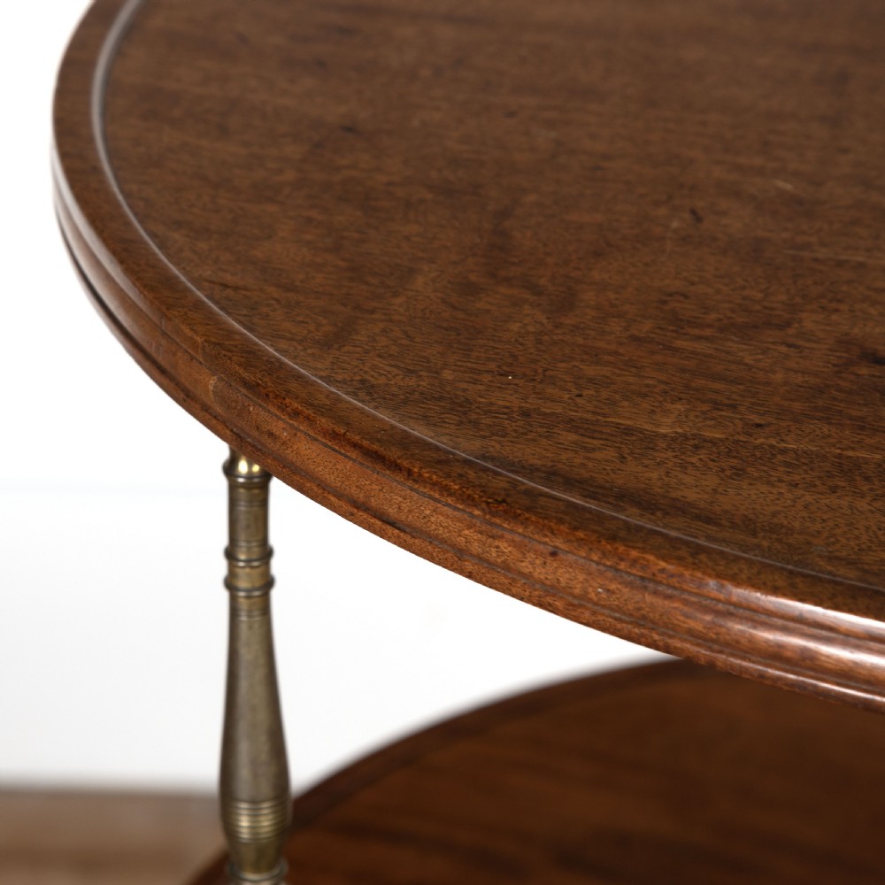 A two-tiered dark mahogany dumbwaiter featuring brass support columns, a fluted central pedestal, and a carved tripod base with paw feet. View VII