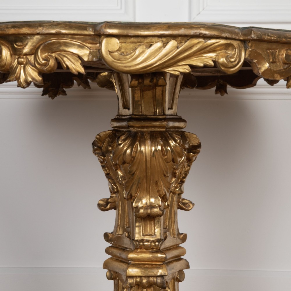 A 19th-century Italian centre table featuring a scalloped green marble top set upon a heavily carved giltwood pedestal base with scroll legs. View VIII