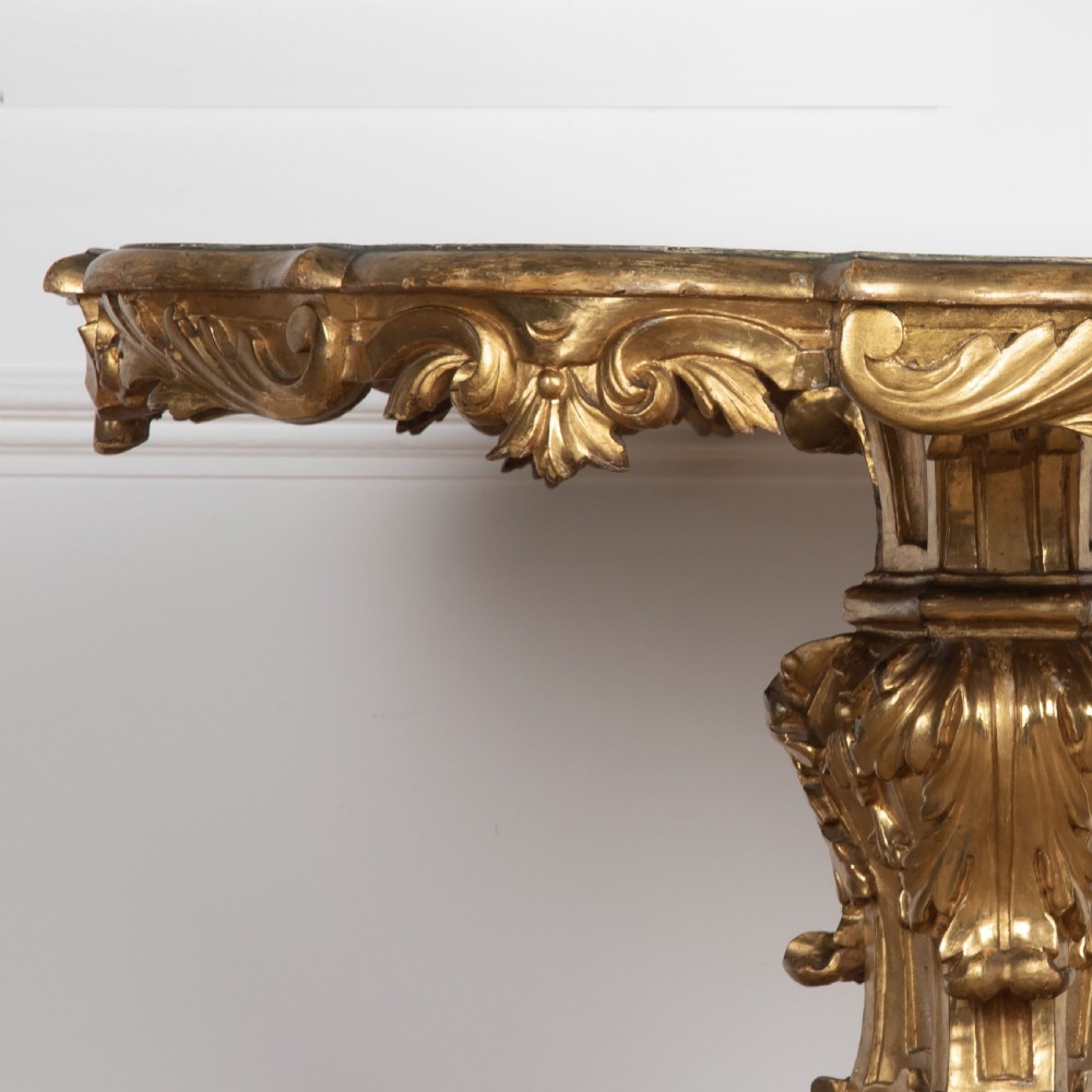 A 19th-century Italian centre table featuring a scalloped green marble top set upon a heavily carved giltwood pedestal base with scroll legs. View IX