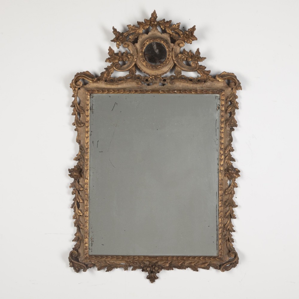A rectangular eighteenth-century Italian giltwood wall mirror featuring a carved floral crest with an oval medallion and silvered glass.