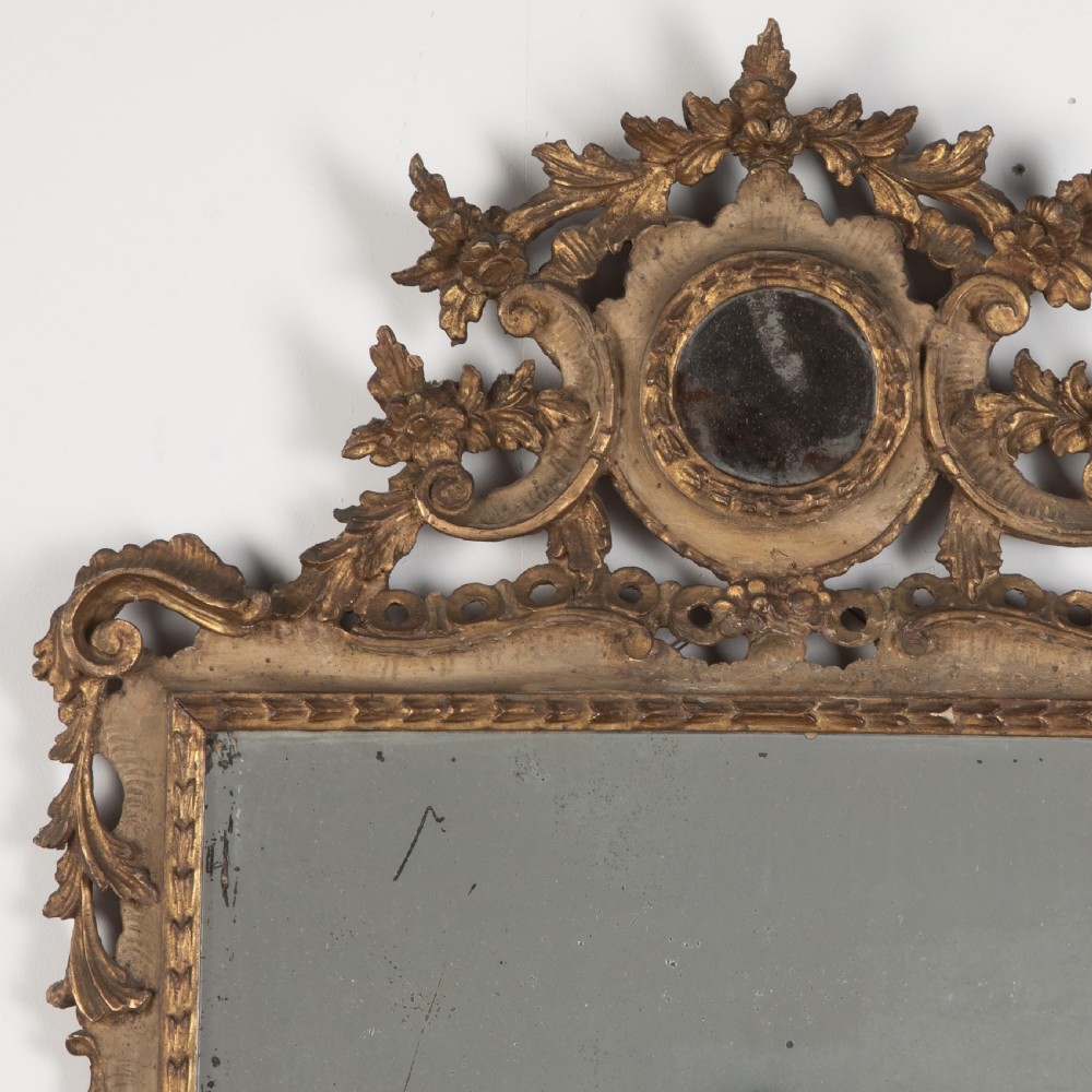 A rectangular eighteenth-century Italian giltwood wall mirror featuring a carved floral crest with an oval medallion and silvered glass. View II