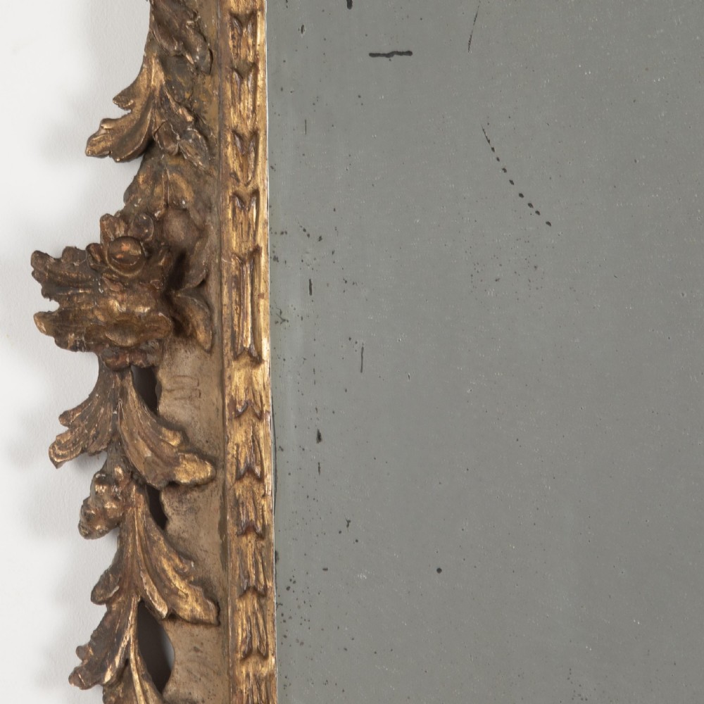A rectangular eighteenth-century Italian giltwood wall mirror featuring a carved floral crest with an oval medallion and silvered glass. View V