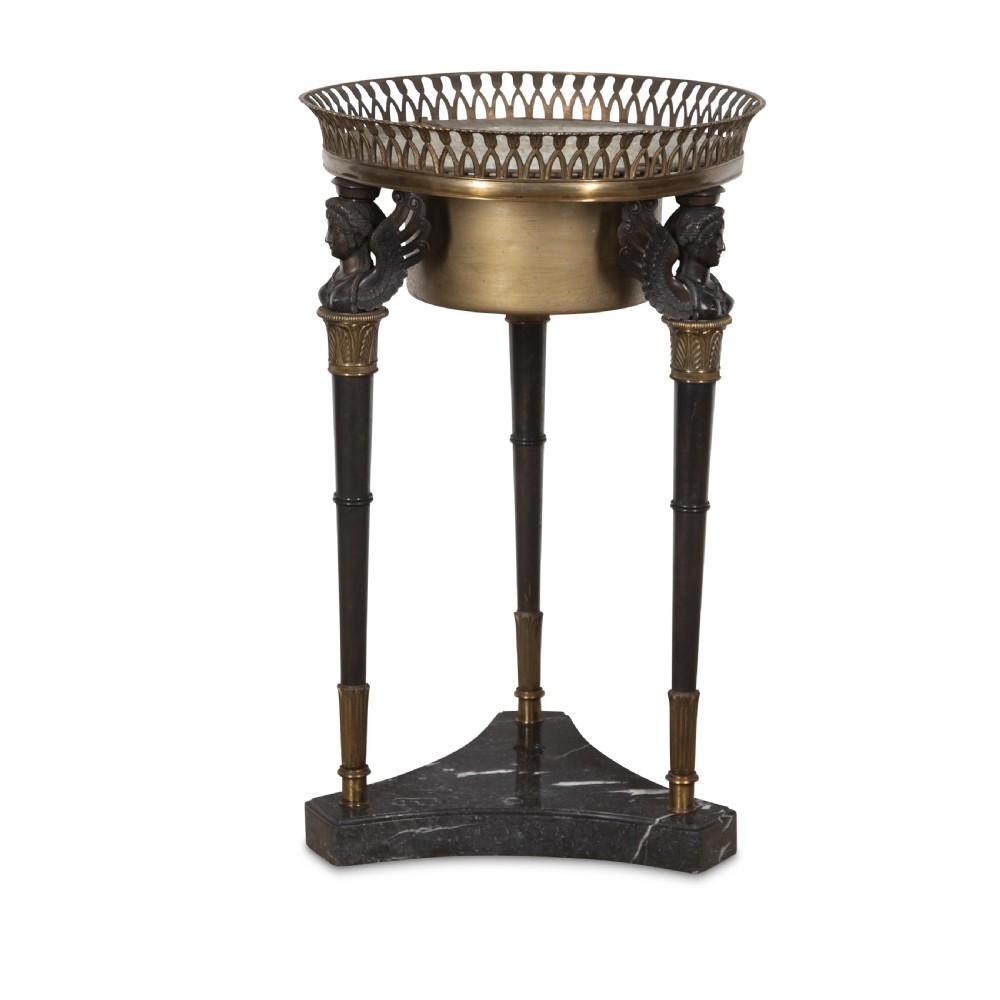 A 19th-century French Empire bronze Athenienne featuring a pierced metal gallery, winged caryatid legs, and a triangular dark marble base. View III