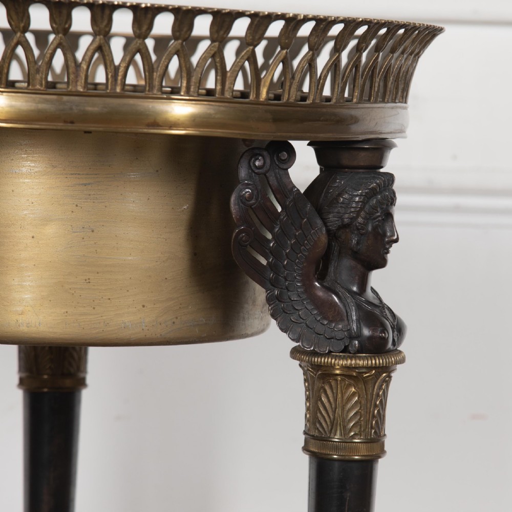 A 19th-century French Empire bronze Athenienne featuring a pierced metal gallery, winged caryatid legs, and a triangular dark marble base. View VIII