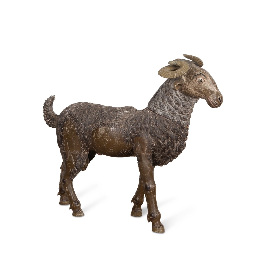 A 19th-century life-size hand-carved wooden goat sculpture with curved horns and a distressed brown painted finish.