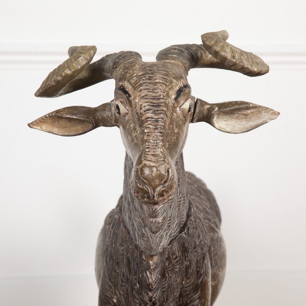 A 19th-century life-size hand-carved wooden goat sculpture with curved horns and a distressed brown painted finish. View IX