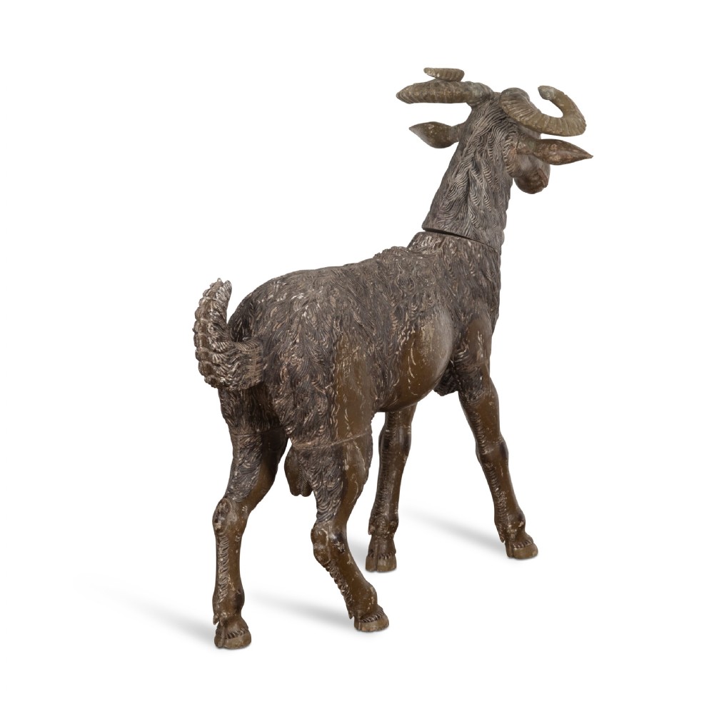 A 19th-century life-size hand-carved wooden goat sculpture with curved horns and a distressed brown painted finish. View X