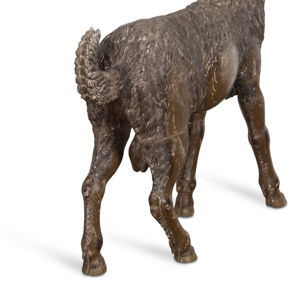 A 19th-century life-size hand-carved wooden goat sculpture with curved horns and a distressed brown painted finish. View XII