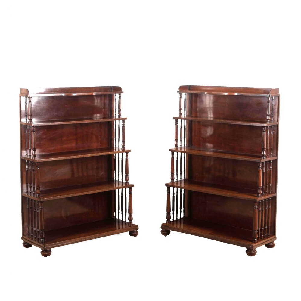 A matching pair of dark brown 19th-century Regency mahogany open bookcases featuring four tiers supported by turned side spindles.