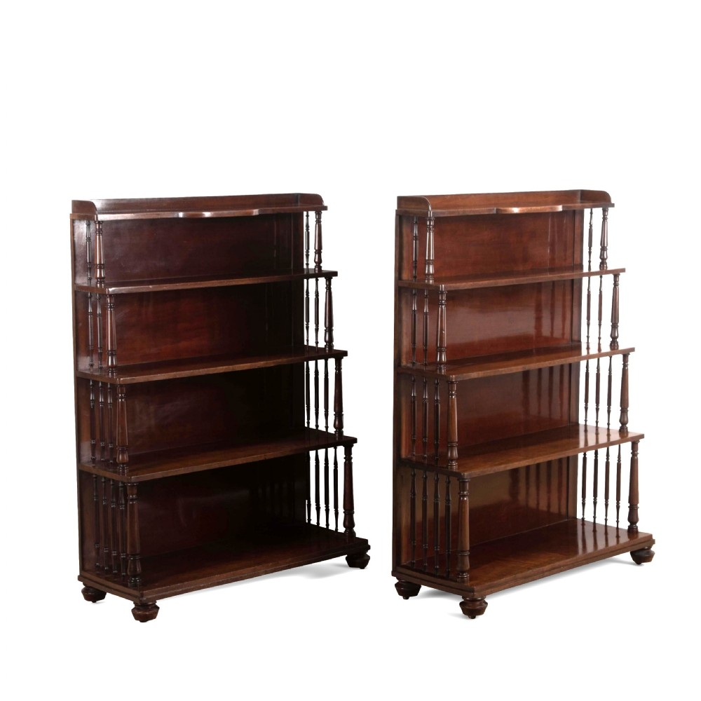 A matching pair of dark brown 19th-century Regency mahogany open bookcases featuring four tiers supported by turned side spindles. View II