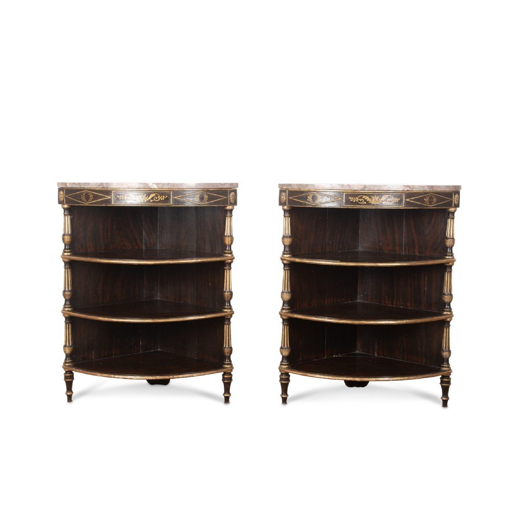 A pair of Regency-style black painted open corner cabinets featuring marble tops, gilt floral scrollwork friezes, and turned support columns. View II