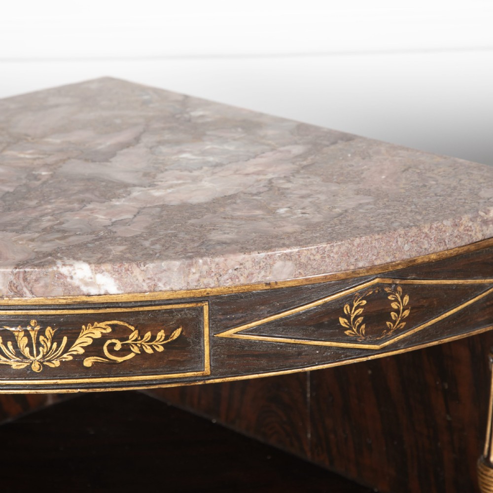 A pair of Regency-style black painted open corner cabinets featuring marble tops, gilt floral scrollwork friezes, and turned support columns. View VII