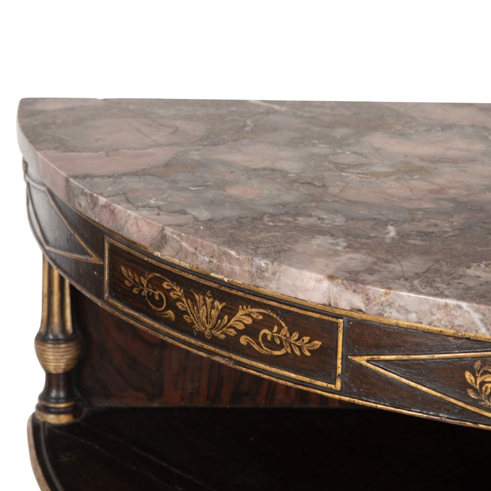 A pair of Regency-style black painted open corner cabinets featuring marble tops, gilt floral scrollwork friezes, and turned support columns. View VIII