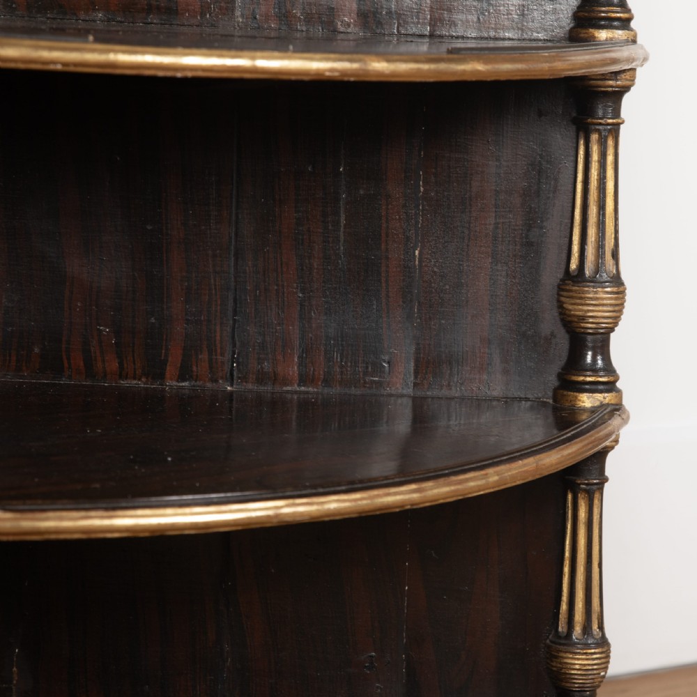 A pair of Regency-style black painted open corner cabinets featuring marble tops, gilt floral scrollwork friezes, and turned support columns. View XI