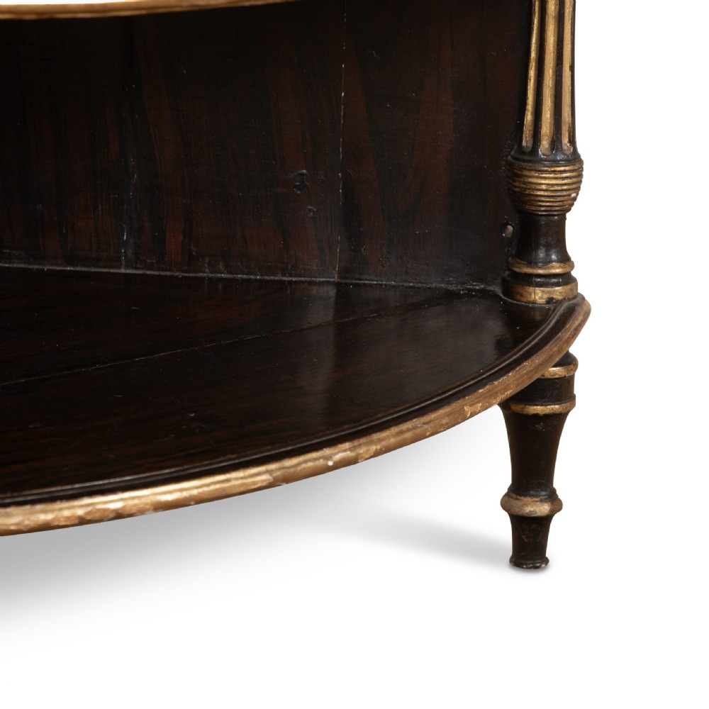 A pair of Regency-style black painted open corner cabinets featuring marble tops, gilt floral scrollwork friezes, and turned support columns. View XII