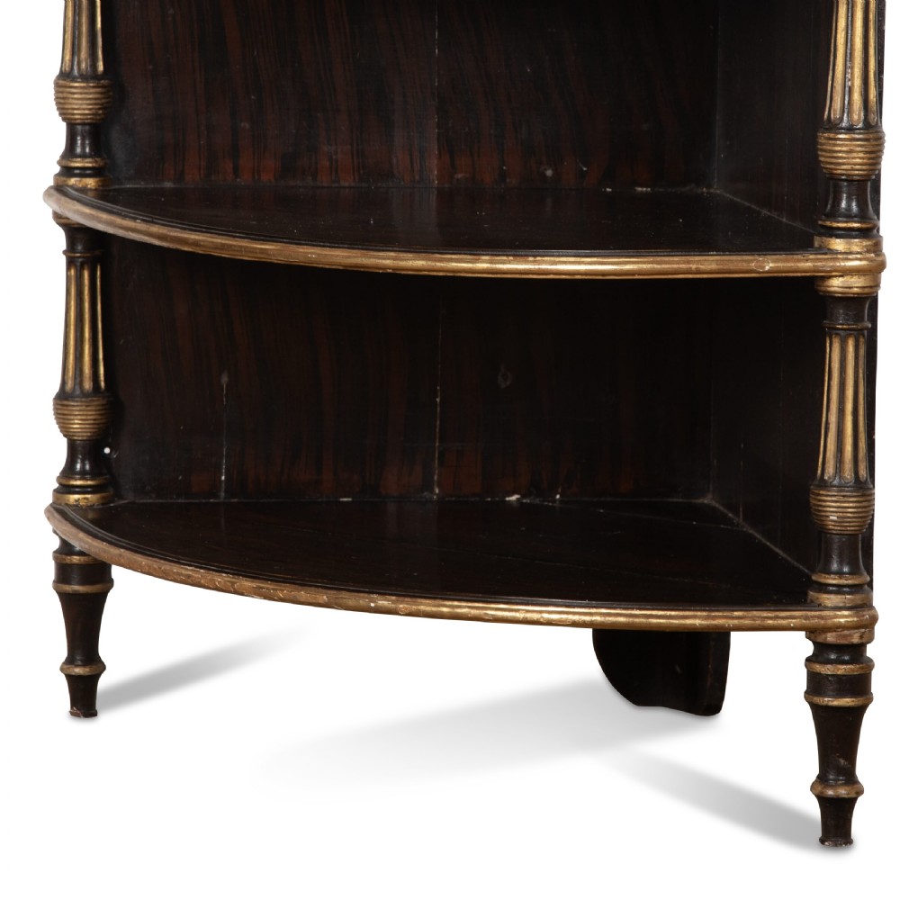 A pair of Regency-style black painted open corner cabinets featuring marble tops, gilt floral scrollwork friezes, and turned support columns. View XIII
