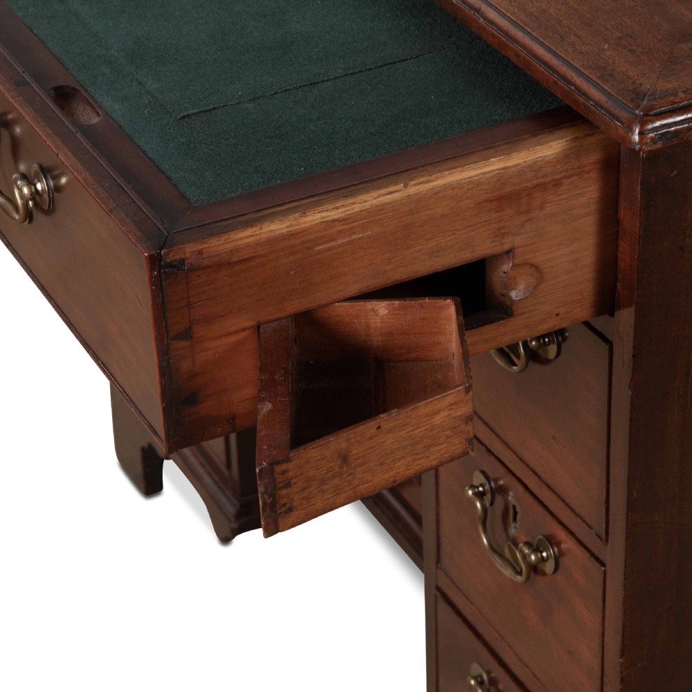 An 18th-century dark mahogany kneehole desk featuring a long top drawer above six side drawers and a central recessed cupboard door with brass handles. View II