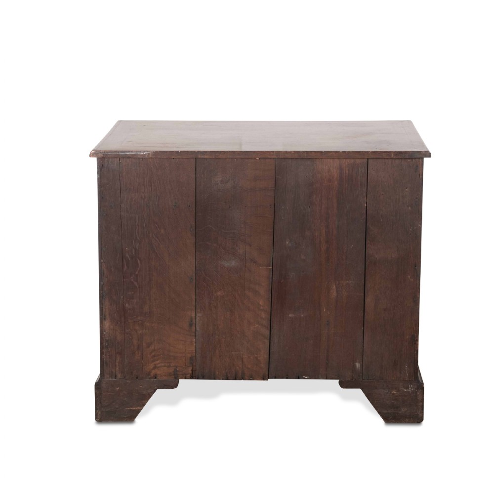 An 18th-century dark mahogany kneehole desk featuring a long top drawer above six side drawers and a central recessed cupboard door with brass handles. View IX
