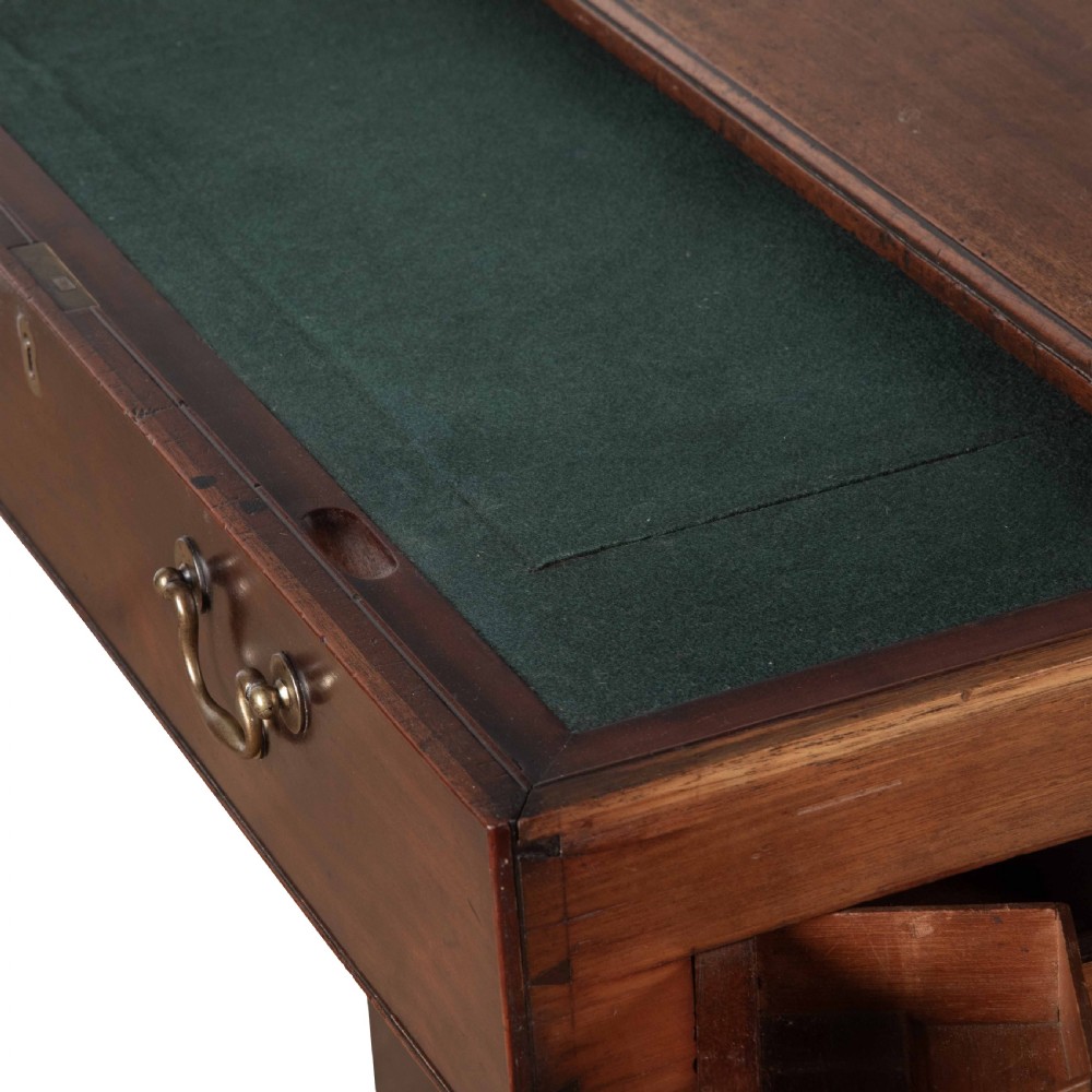 An 18th-century dark mahogany kneehole desk featuring a long top drawer above six side drawers and a central recessed cupboard door with brass handles. View XII