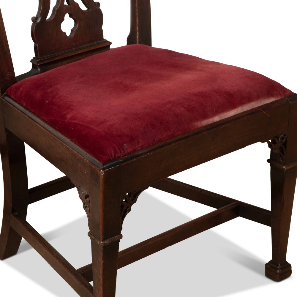A pair of 18th-century mahogany side chairs featuring pierced Gothic tracery splats and red velvet upholstered seats. View V