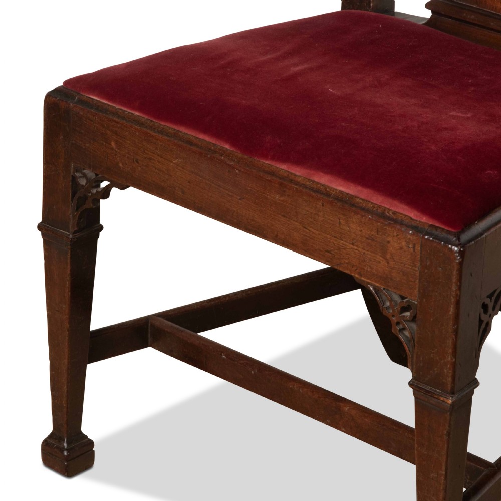 A pair of 18th-century mahogany side chairs featuring pierced Gothic tracery splats and red velvet upholstered seats. View VI