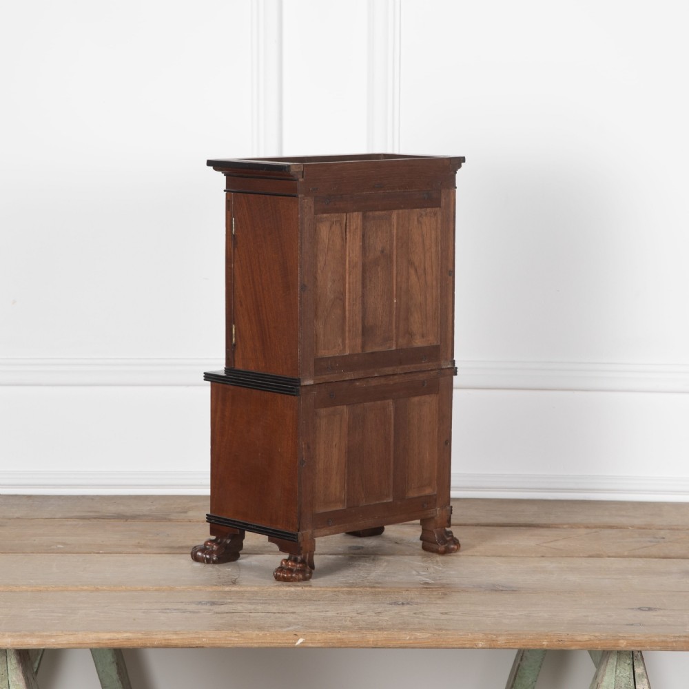 A 19th-century miniature Anglo-Indian hardwood linen press featuring panelled cupboard doors over three drawers, set on carved lion paw feet. View VIII