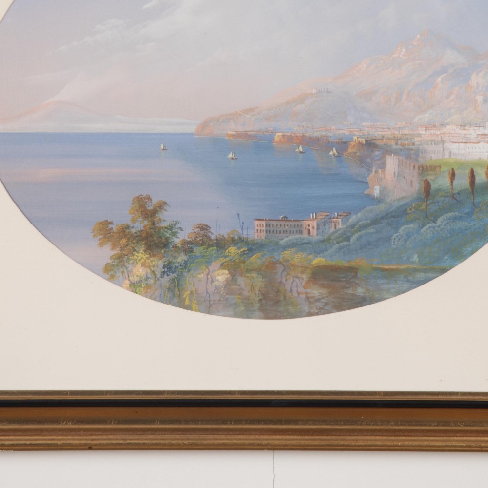 A pair of 19th-century gilt-framed landscape paintings depicting oval coastal views of the Bay of Naples in gouache on paper. View IV
