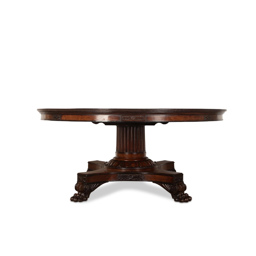 A circular Regency mahogany centre table featuring a carved frieze, a fluted pedestal column, and a concave four-legged plinth base with carved feet. View III