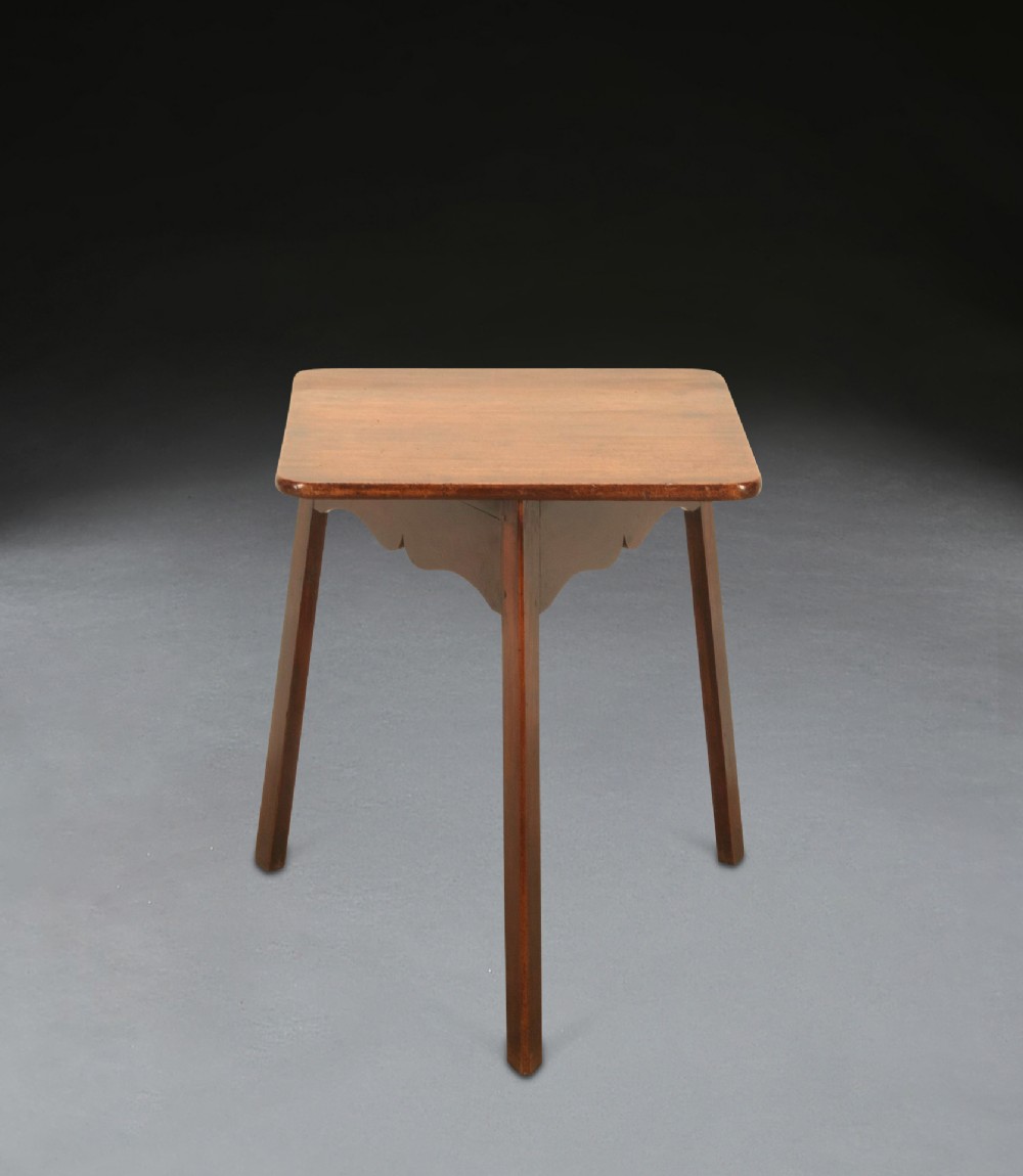 A George III mahogany and fruitwood three-legged cricket table with a square top with rounded corners and shaped aprons.