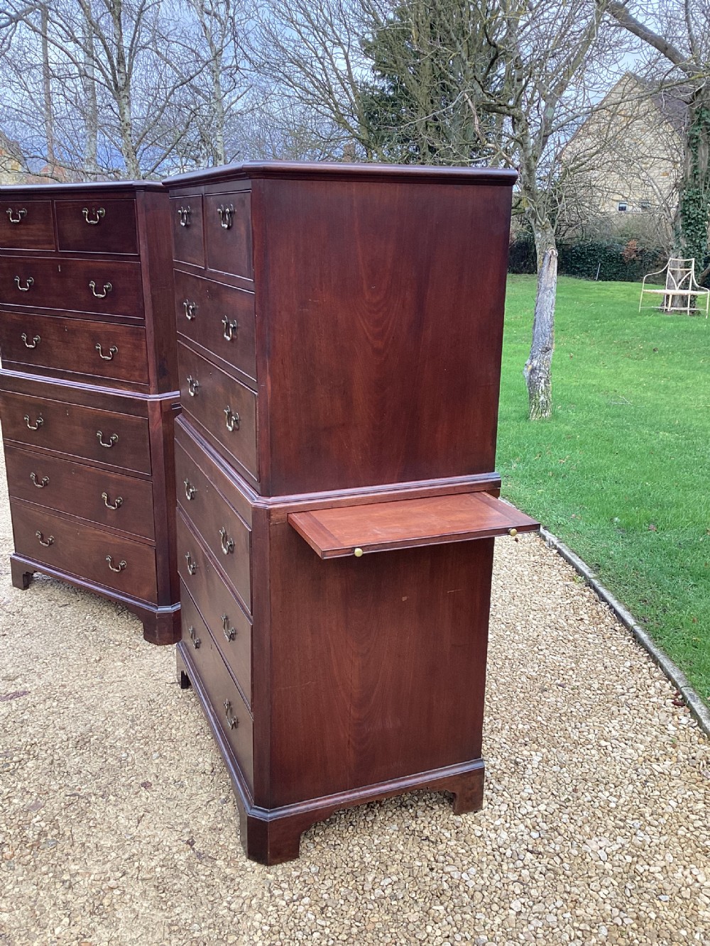 A pair of antique George II mahogany chests on chests featuring brass swan-neck handles and raised bracket feet. View IX