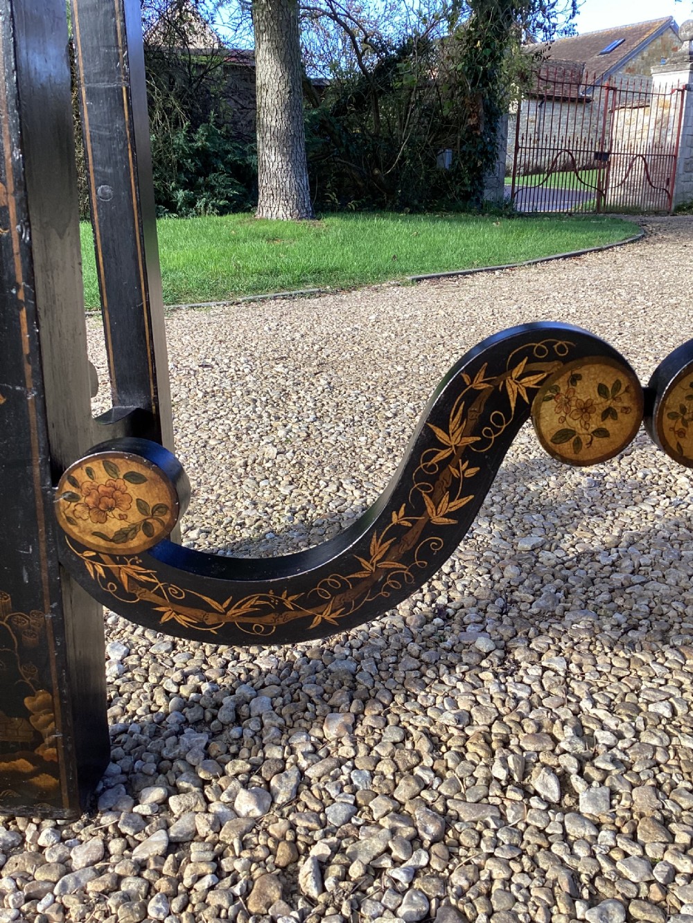 A Regency period black lacquer cabinet on stand, featuring gilt Chinoiserie landscape and floral scenes, open double doors, and fitted internal drawers surrounding a central panel. View X