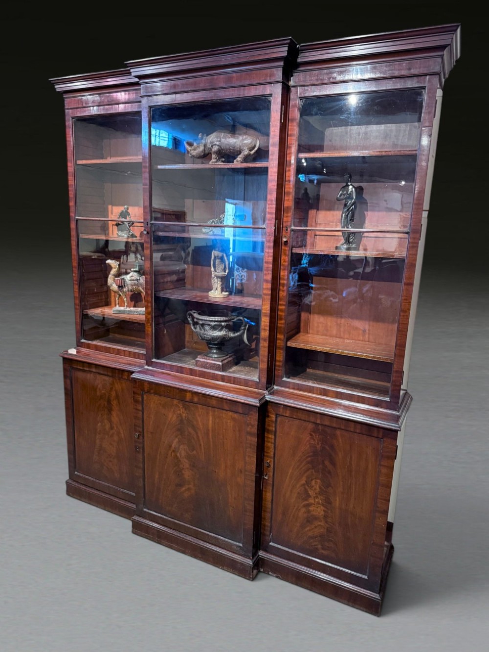 A Georgian flame mahogany breakfront bookcase featuring glazed upper doors and panelled lower cupboard doors. View III