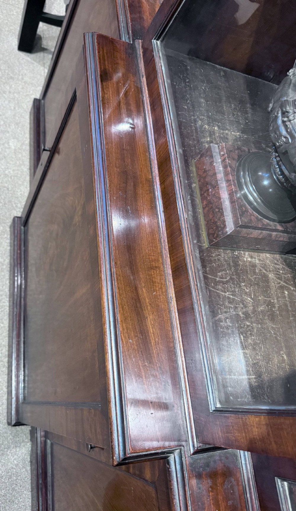 A Georgian flame mahogany breakfront bookcase featuring glazed upper doors and panelled lower cupboard doors. View VII