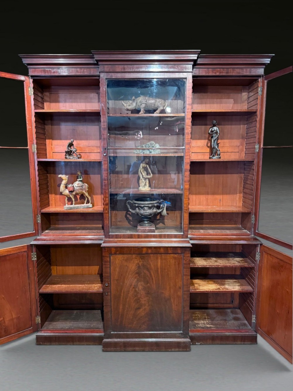 A Georgian flame mahogany breakfront bookcase featuring glazed upper doors and panelled lower cupboard doors. View XIV