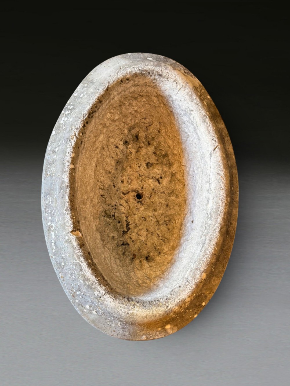 A hand-carved 18th-century grey marble cistern featuring a wide moulded rim and a heavy circular pedestal base. View VII